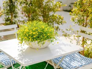 una mesa blanca con un tazón de flores amarillas. en Ideal Rooms, en Porto Cesareo