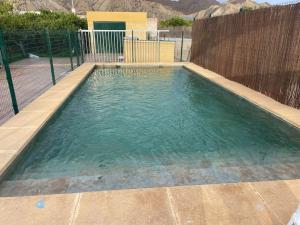 une petite piscine avec une clôture en bois dans l'établissement Agradable casa de campo, à Gádor