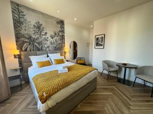 een hotelkamer met een bed en een tafel en stoelen bij PALAIS DES FESTIVALS à 3 min - Croisette - Plage in Cannes