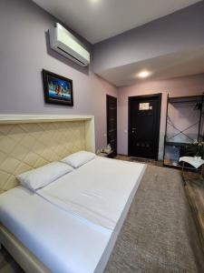 a bedroom with a large white bed and a flat screen tv at Sport Point Hotel in Khimki