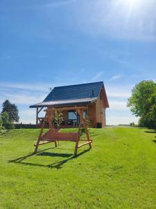 ein Haus mit einem Sonnendach auf einem Feld in der Unterkunft Grześny Domek in Zbiczno