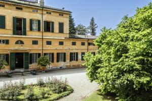 摩德納的住宿－Villa Vandelli - Nel cuore della Motor Valley，一座有树木的古老建筑
