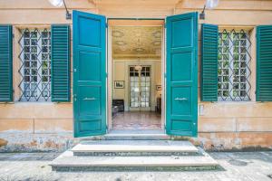 an open doorway to a building with blue shutters at Villa Vandelli - Nel cuore della Motor Valley in Modena