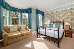 a bedroom with a bed and a couch and windows at Burnside B&B in Keswick