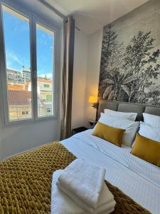 een slaapkamer met een groot bed en een groot raam bij PALAIS DES FESTIVALS à 3 min - Croisette - Plage in Cannes