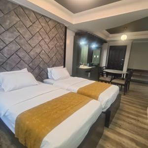 ein Hotelzimmer mit 2 Betten und einem Tisch in der Unterkunft MO2 Westown Hotel - Mandalagan in Bacolod City