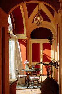 un patio con mesa, sillas y una lámpara de araña en Casa Giulia - sophisticated apartment with view, en Positano