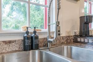 Un fregadero de cocina con dos botellas de vino encima. en Free parking, Walk to Botanical Garden, PS4, Grill, Private fenced backyard, Pets allowed, en San Antonio 85 fotos más