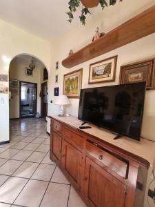 sala de estar con TV de pantalla plana grande en un centro de entretenimiento de madera en Casa Anna Maria, en Iglesias