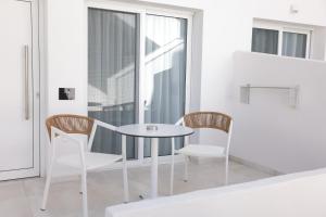 a white table and chairs in a room with a window at Lefko Suites in Hanioti