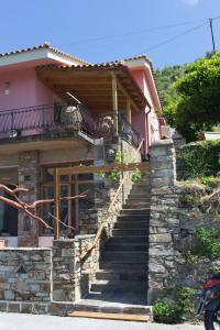 a house with stairs in front of it at Kouklospito Agios Polykarpos in Raches