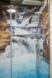 a shower with a waterfall mural on the wall at La Cascade et des Halles in Dijon