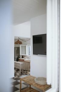 a living room with a television on a wall at Yi & Thalassa Living by KHI in Kithnos