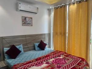 a bedroom with a bed and a window with yellow curtains at Modern Home 2BHK 3ACs 2Bathrooms Terrace Nr Laxman Jhulla in Rishīkesh