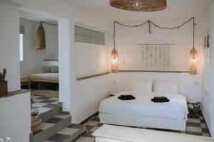 a bedroom with a white bed and a couch at Yi & Thalassa Living by KHI in Kithnos