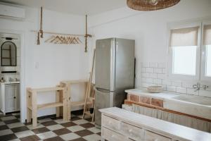 a kitchen with a refrigerator and a checkered floor at Yi & Thalassa Living by KHI in Kithnos +54 photos