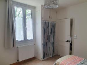 a bedroom with a bed and a window at La Maison du Druide in Bonneuil-en-Valois
