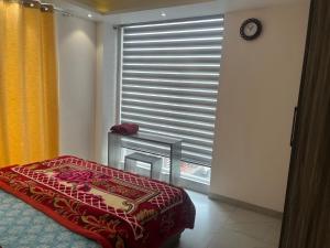 a bedroom with a bed and a window with blinds at Modern Home 2BHK 3ACs 2Bathrooms Terrace Nr Laxman Jhulla in Rishīkesh