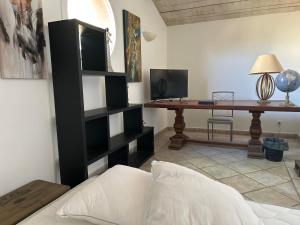 ein Wohnzimmer mit einem schwarzen Bücherregal und einem Schreibtisch in der Unterkunft Maison de charme en bord de mer in Lucciana