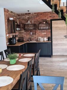 a dining room with a table and a kitchen at Zielnisko in Firlej +17 photos