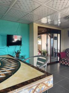 a living room with a flat screen tv and a couch at Hostal bajo las estrellas in Chicá