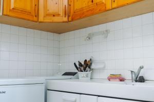 - une cuisine carrelée de blanc avec un comptoir et un évier dans l'établissement Appartement sain et paisible à Lyon, à Lyon