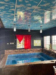 a swimming pool with a painting on the ceiling at Hostal bajo las estrellas in Chicá