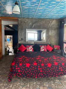a bedroom with a bed with red stars on it at Hostal bajo las estrellas in Chicá