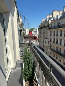- un balcon dans un bâtiment arboré dans l'établissement Hotel Moulin Plaza, à Paris
