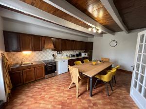 eine Küche mit einem Holztisch und gelben Stühlen in der Unterkunft Gîte du Dolmen in Guiscriff