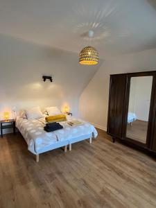 ein Schlafzimmer mit einem Bett und einem großen Spiegel in der Unterkunft Gîte du Dolmen in Guiscriff