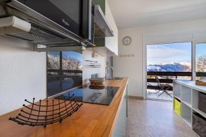 a kitchen with a counter with a view of mountains at Lou Moussu in Gourette