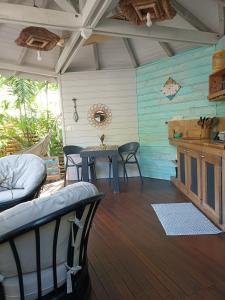 a room with a table and chairs on a deck at TIKI PARADISE LODGE FWI in Sainte-Anne