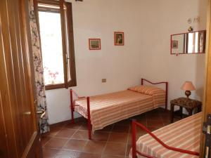 a bedroom with two beds and a window at Villa dei Pini , Solanas Villasimius in Solanas