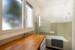 a bathroom with a sink and a tub and a window at Lou Moussu in Gourette