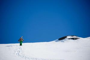 una persona parada en la cima de una montaña cubierta de nieve en Katterjokk Turiststation, en Riksgränsen