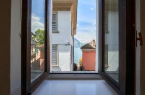 een open raam met uitzicht op het water bij SISTERS' HOUSE in Varenna