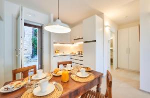 een keuken en eetkamer met een houten tafel en stoelen bij SISTERS' HOUSE in Varenna