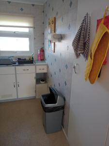 a kitchen with a sink and a trash can at Chalet at California Sands in Scratby