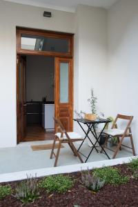 a patio with a table and chairs next to a door at Nidos Accommodation Gaia in Vila Nova de Gaia