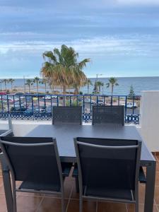 een tafel en stoelen op een balkon met uitzicht op de oceaan bij mirazul mojacar in Mojácar