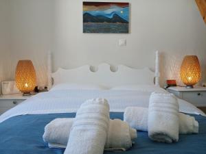 Un dormitorio con una cama blanca con toallas. en Hydra Memories House, en Hydra