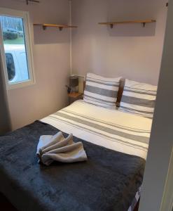 Un dormitorio con una cama con una toalla. en mobil home, en Mirgaudon