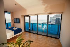 a room with a bed and a large glass window at ORBI CITY Beautiful Luxurios Panoramic View on batumi in Batumi