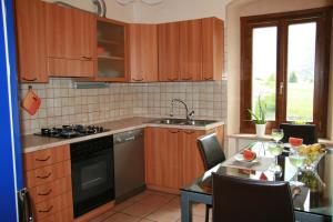 Una cocina con una mesa, un fregadero y una estufa. en Appartamento sul Lago di Molveno, en Molveno