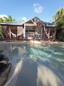 a swimming pool in front of a house at TIKI PARADISE LODGE FWI in Sainte-Anne