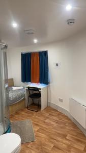 ロンドンにあるNot Very Quiet But Best Locationのデスク、窓、トイレが備わる客室です。
