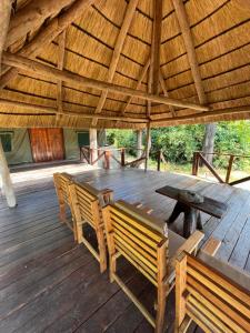 una mesa de madera y bancos en una terraza de madera en Bua River Lodge, 