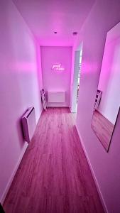 una stanza con pareti viola e pavimenti in legno e un soffitto rosa di Nouvel appart cosy, centre Tours a Tours