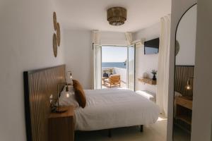 a bedroom with a bed and a view of the ocean at H Bellavista Mojácar in Mojácar
